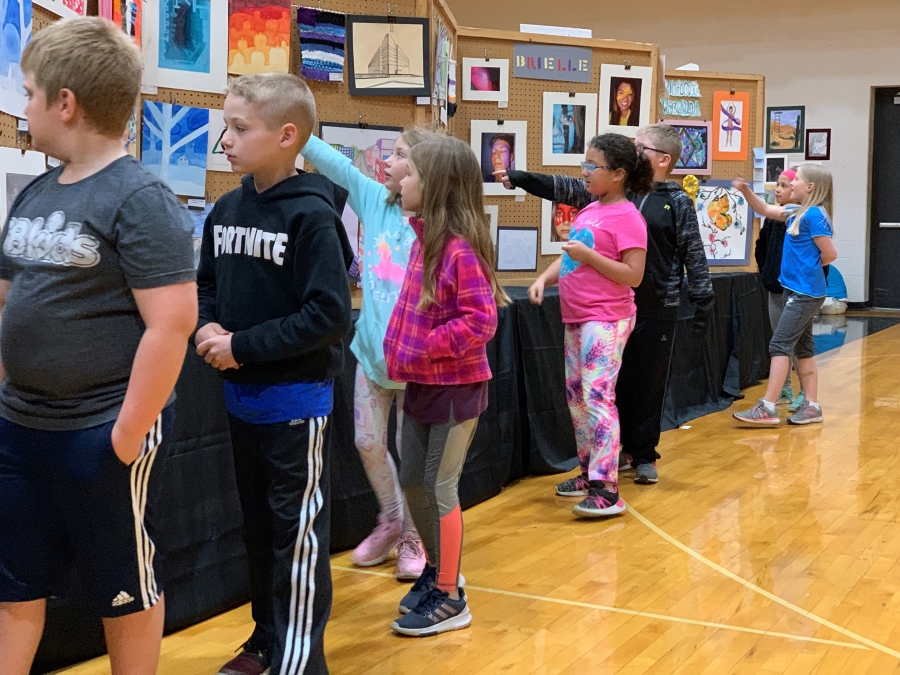 students pointing at works of art